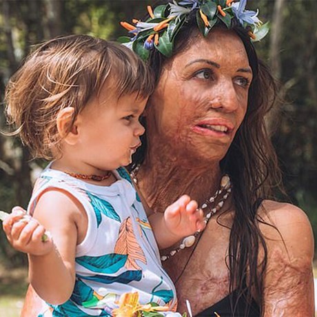 Turia Pitt holding son Hakavai on first birthday with garlands in their hair