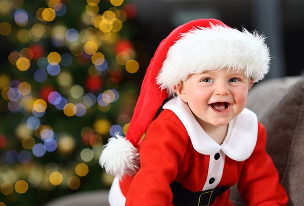one-year-old baby smiling dressed as Santa