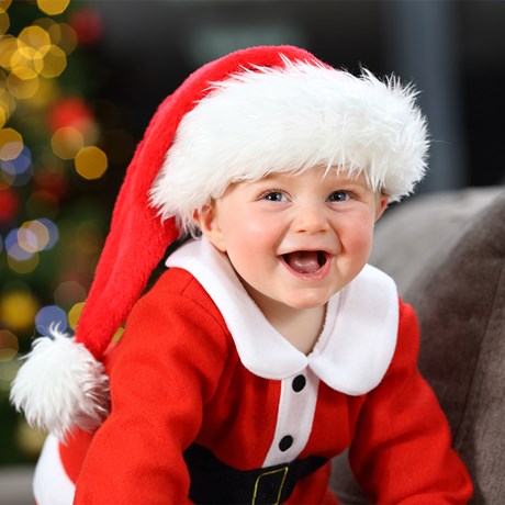 one-year-old baby smiling dressed as Santa