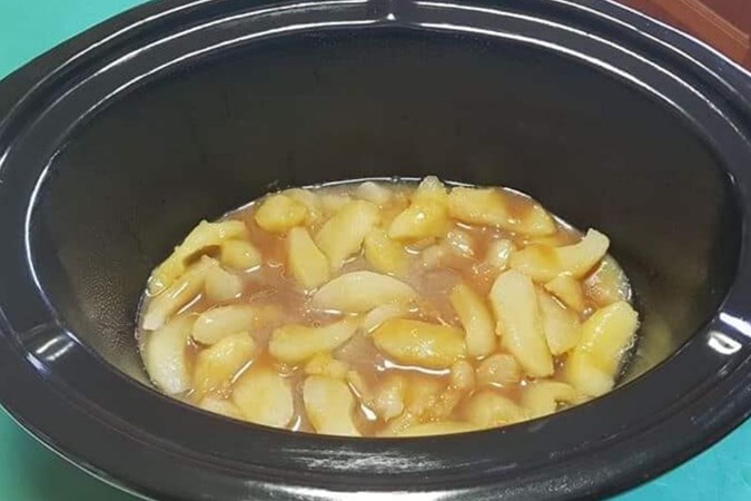 Place the apple slices and apple sauce in first. Image: Slow Cooker Recipe & Tips/Facebook